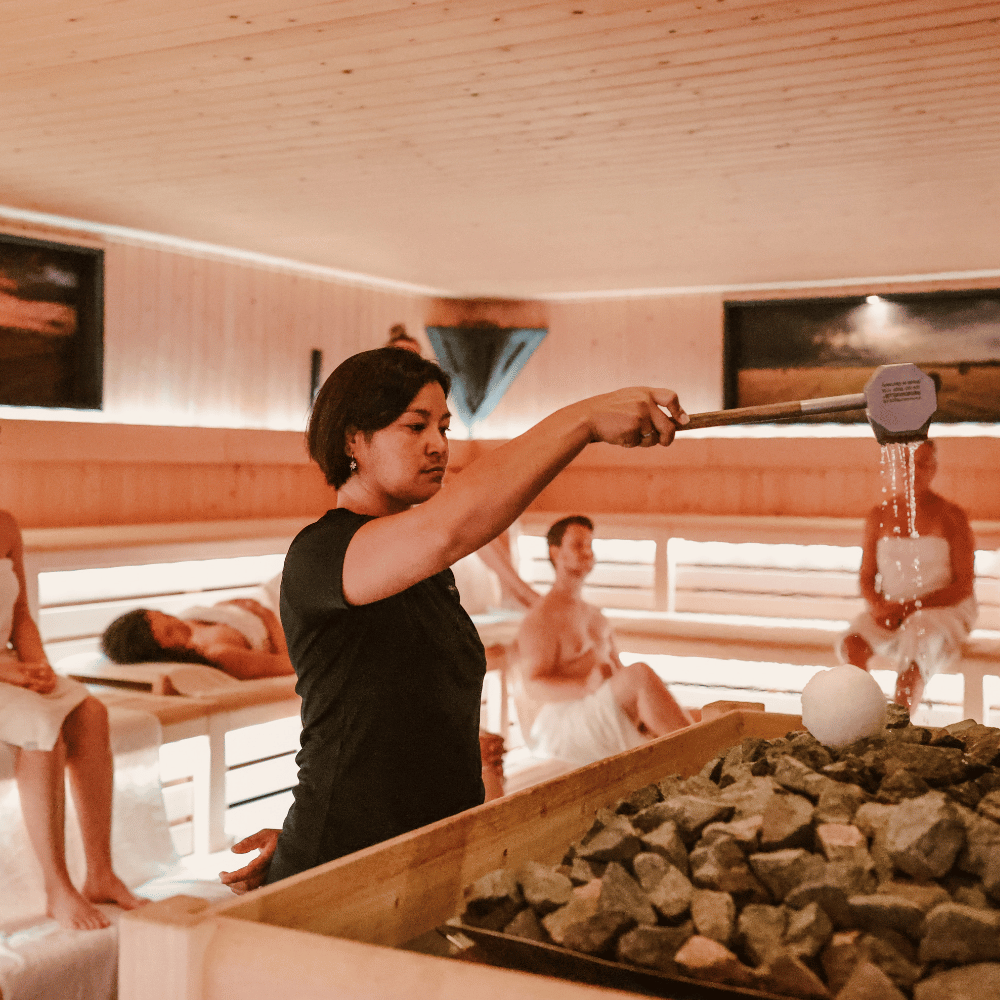 vrouw doet een opgieten in de sauna